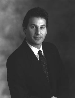 Studio portrait of Alan Baratz in a dark suit and tie.