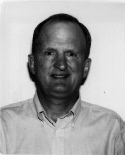 Black and white portrait of Harvey Fraser in an open-necked shirt.
