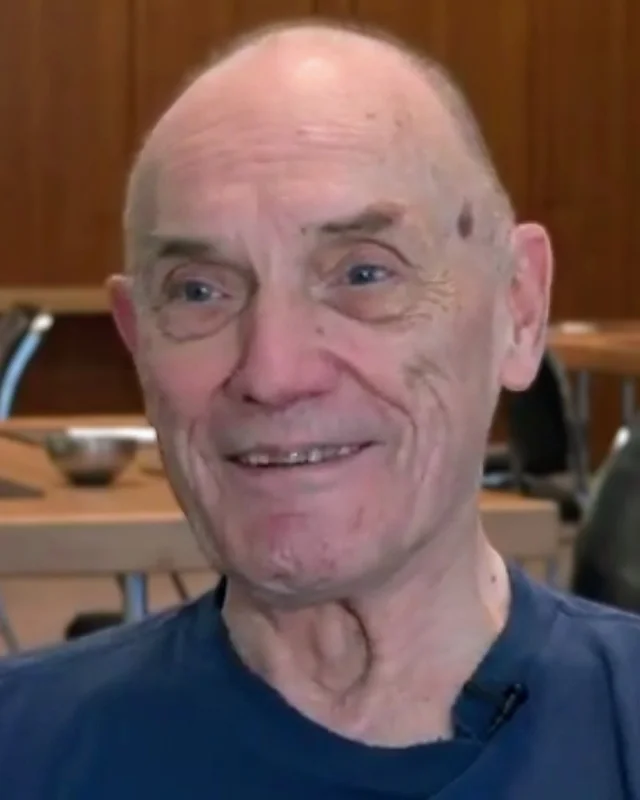 Stephen Wolff in close-up, smiling, seated in a meeting room during a recorded interview.